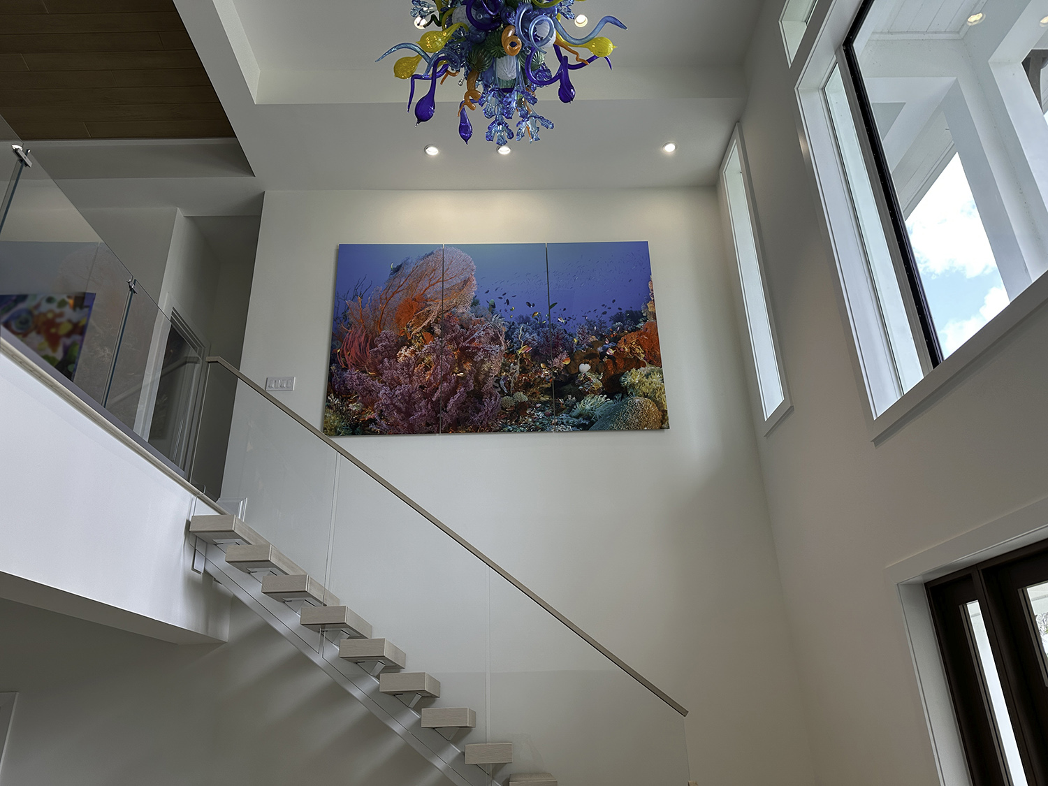 Large, vibrant coral reef photo art above stairs