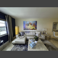 Riot 72x48 over couch a large photograph of orange anthias fish swimming around orange corals on a reef hangs in a liging room