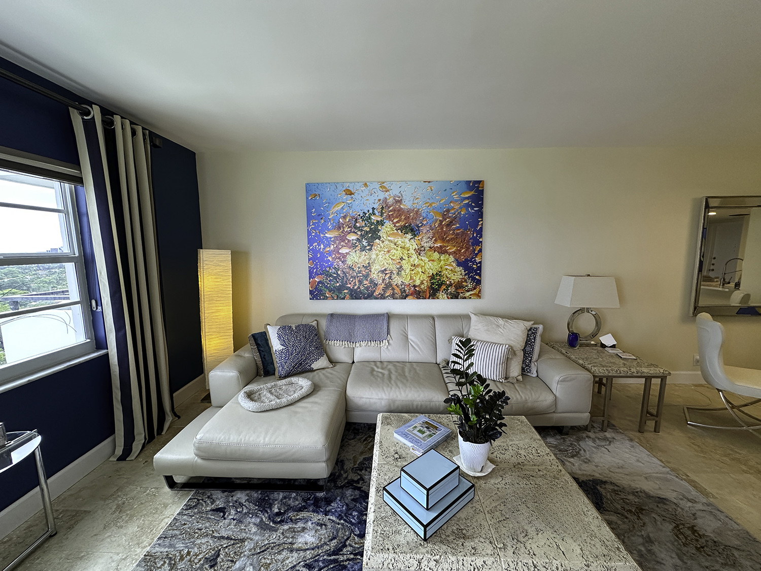 Riot 72x48 over couch a large photograph of orange anthias fish swimming around orange corals on a reef hangs in a liging room