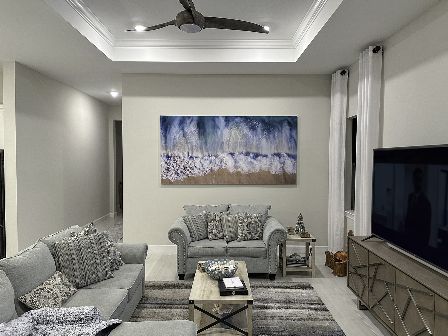 Riptide 96x48 in Living Room a large aerial photograph of waves crashing on a sndy beach is art above a couch