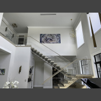 large underwater abstract art photograph of a cabbage coral is hung above a stairwell