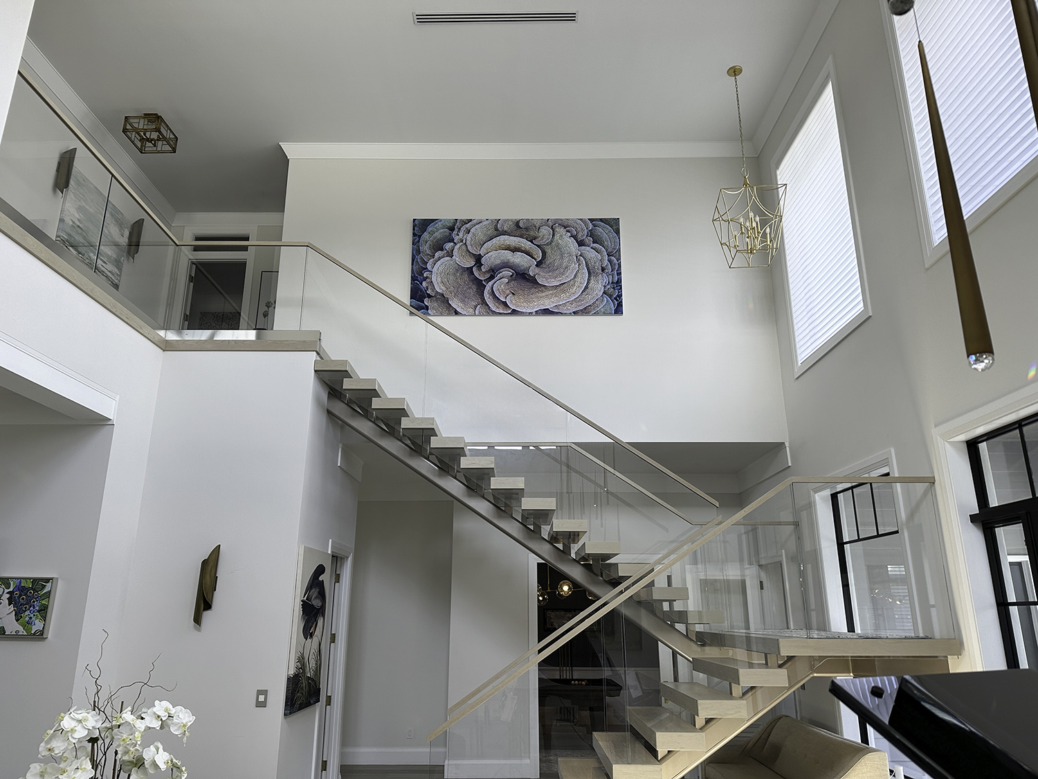 large underwater abstract art photograph of a cabbage coral is hung above a stairwell