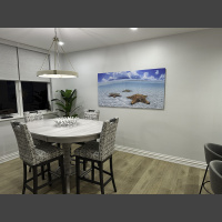 large art underwater photograph of three starfish in shallow water over white sand, displayed in a dining room