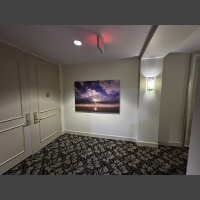 large art beachscape photograph of a moonrise over a wave, displayed in an elevator lobby
