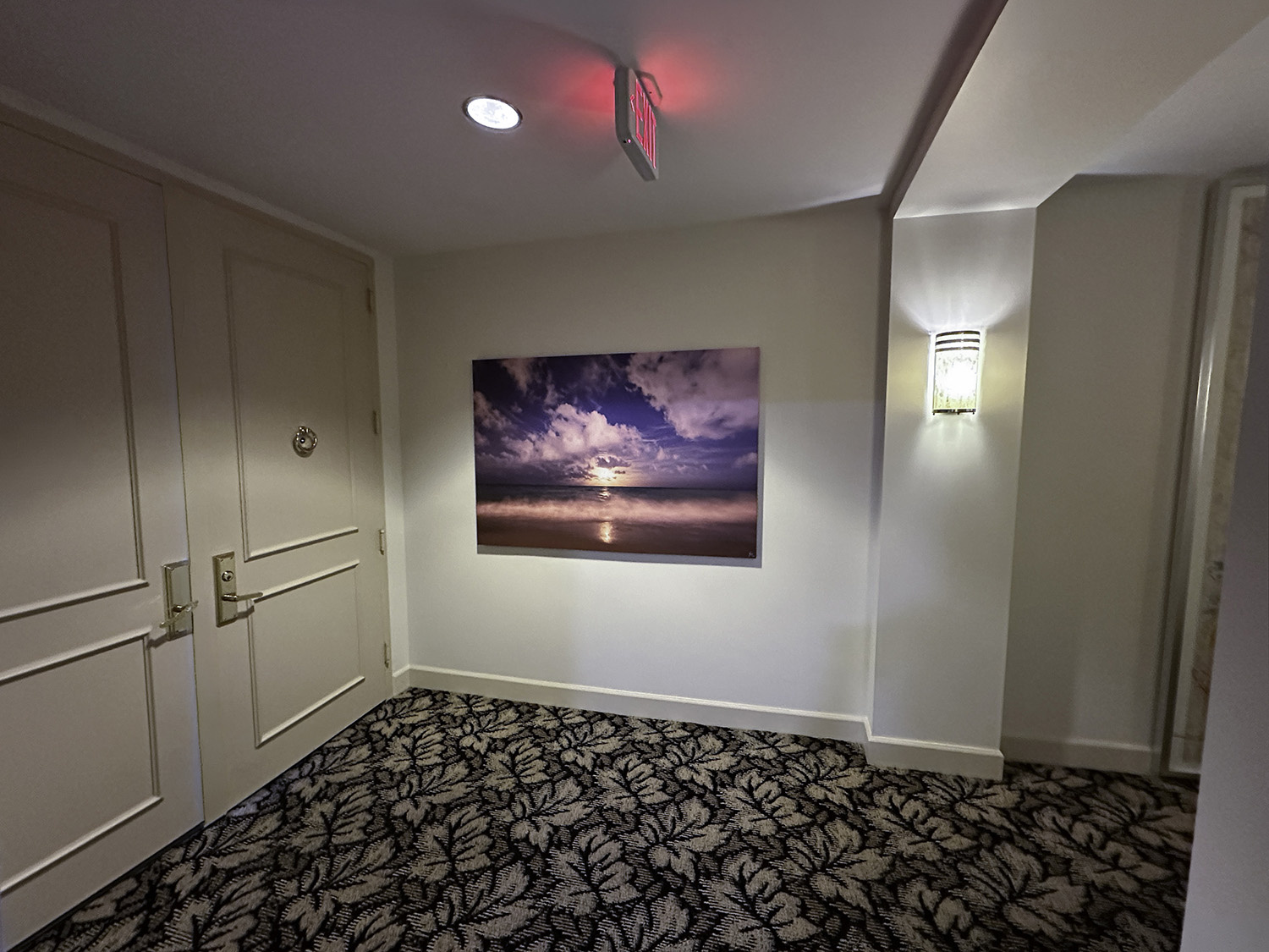 large art beachscape photograph of a moonrise over a wave, displayed in an elevator lobby