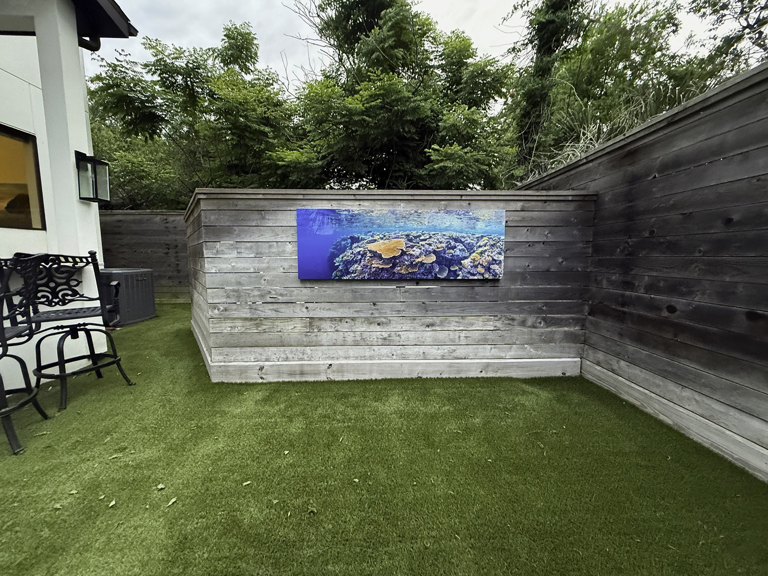 large fine art underwater photograph of a wall of coral, displayed outdoors on a privacy wall