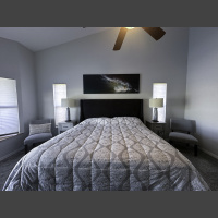 large fine art underwater photograph of an ocean wave, displayed above a king bed