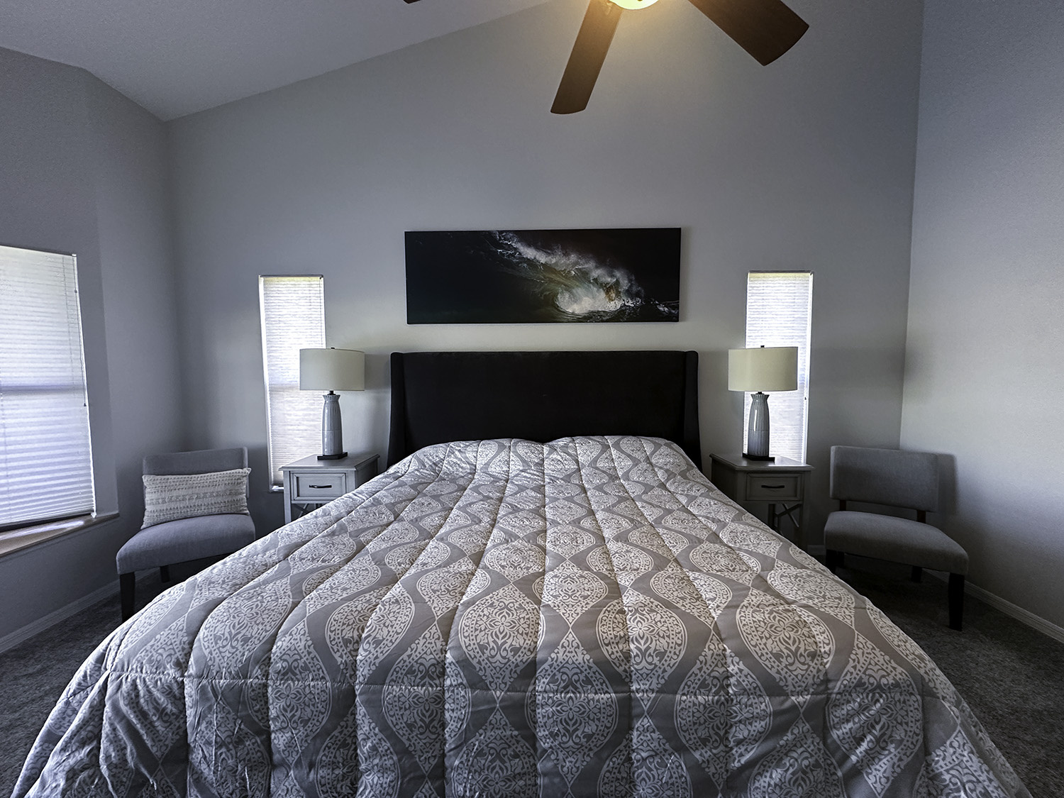 large fine art underwater photograph of an ocean wave, displayed above a king bed